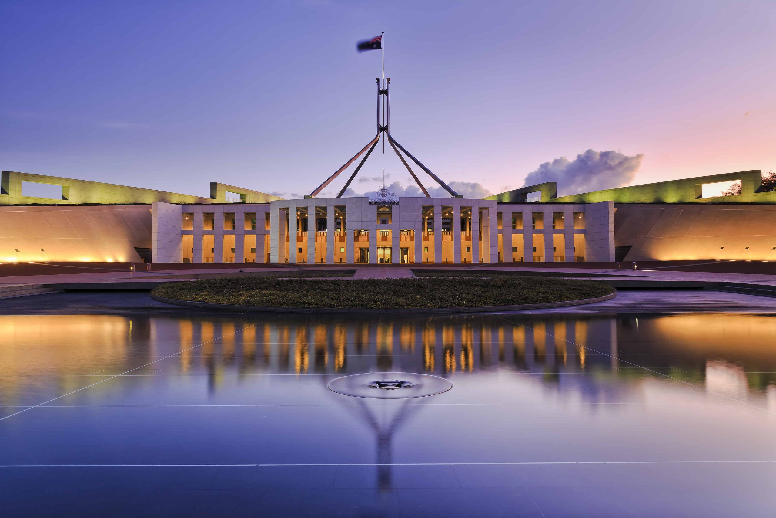 Colourful reflection of Canberra's new parliament building in a fountain pond at sunset.