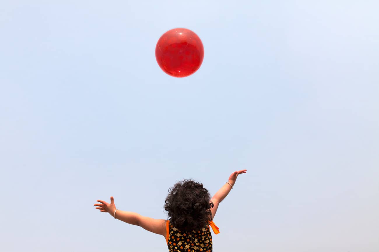 kid playing with red ball