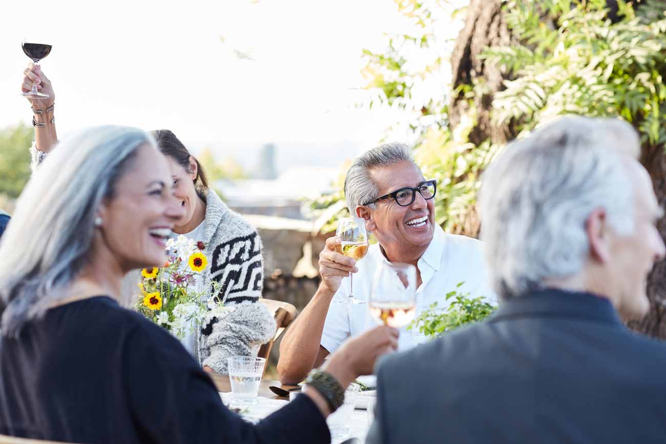 group of seniors toasting together in an outdoor table