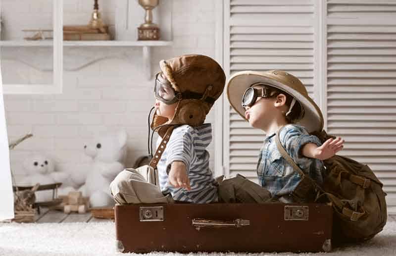 Two boys in the form of an aircraft pilot and traveler playing in her room
