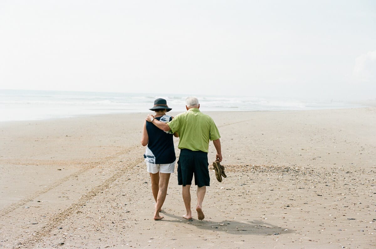 older couple walking on the beach