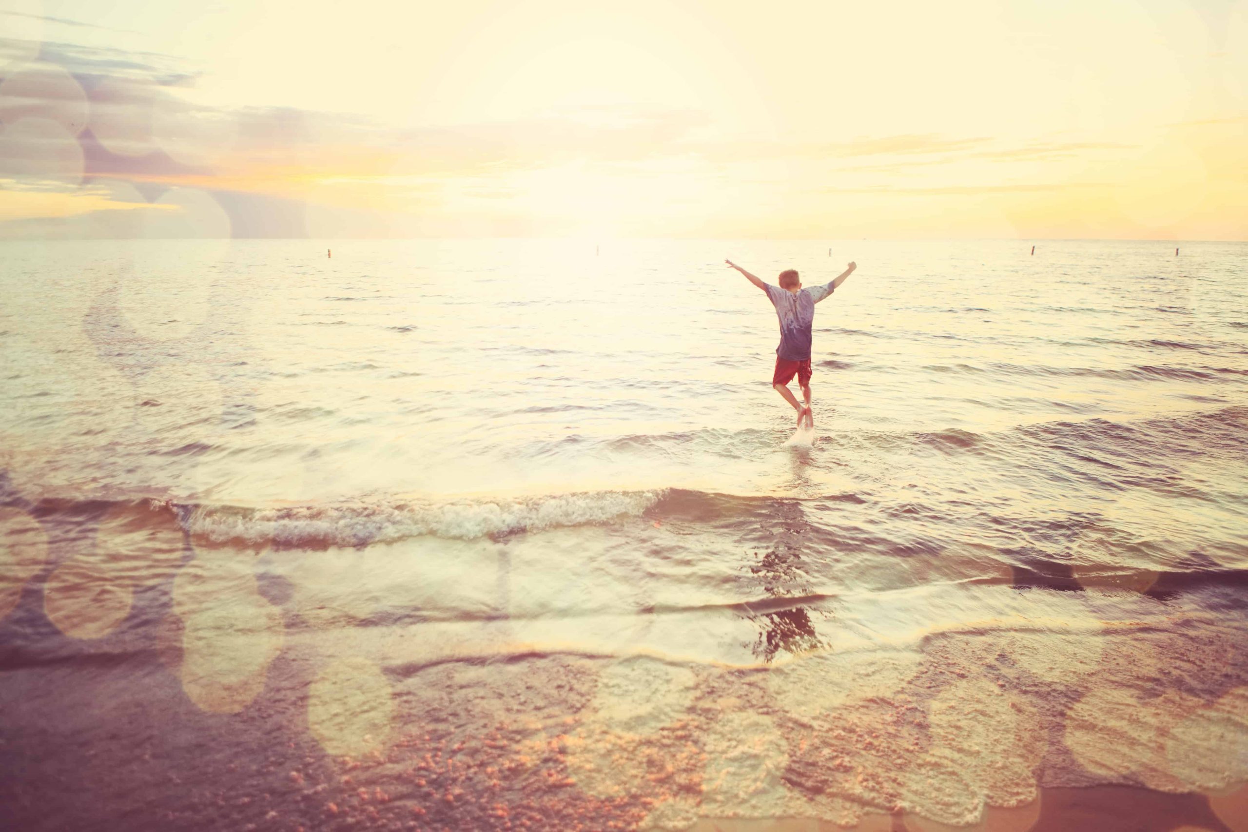 Boy happily playing by the shore