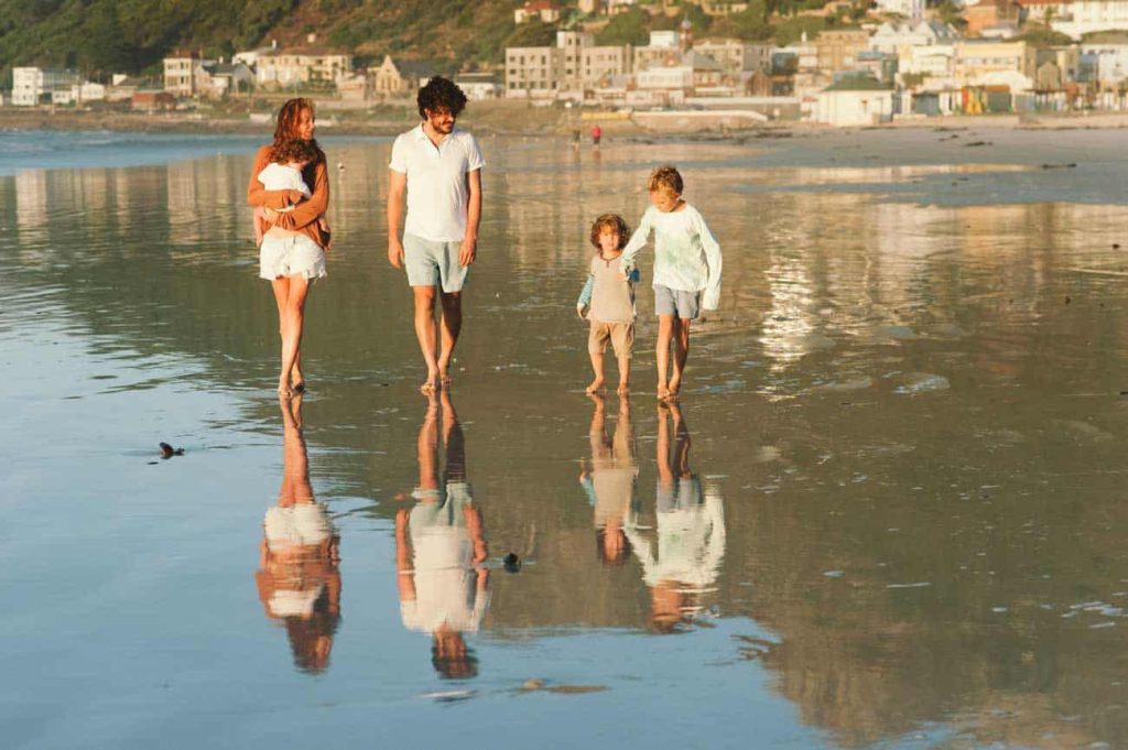 A family walks along the beach in the early morning light. wealth protection main