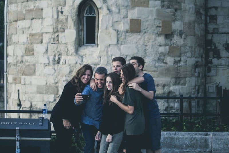 family taking a picture on vacation happiness discretionary income